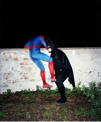 Batman helfen Spiderman klettern über eine Mauer